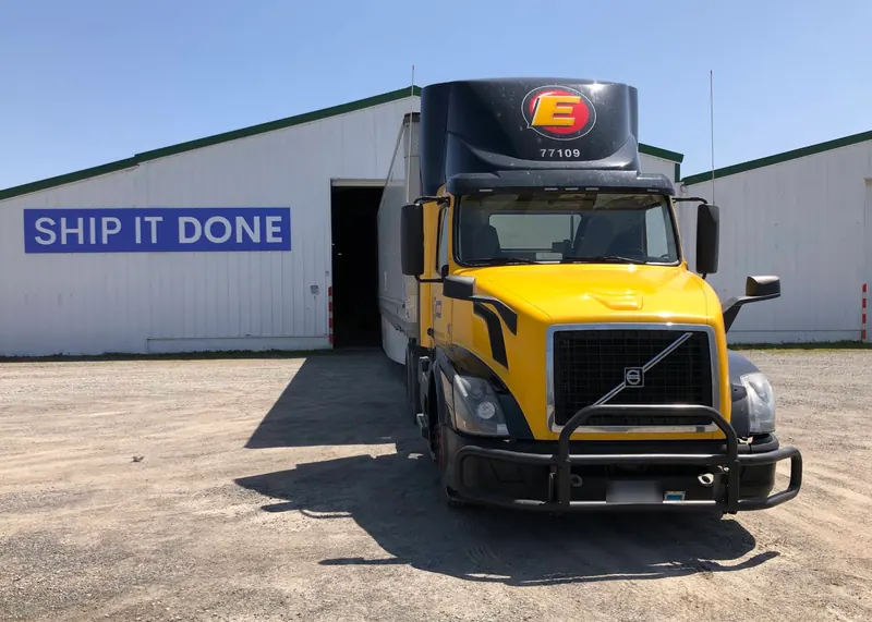 Our warehouse in daylight, with a freight truck at an open dock door